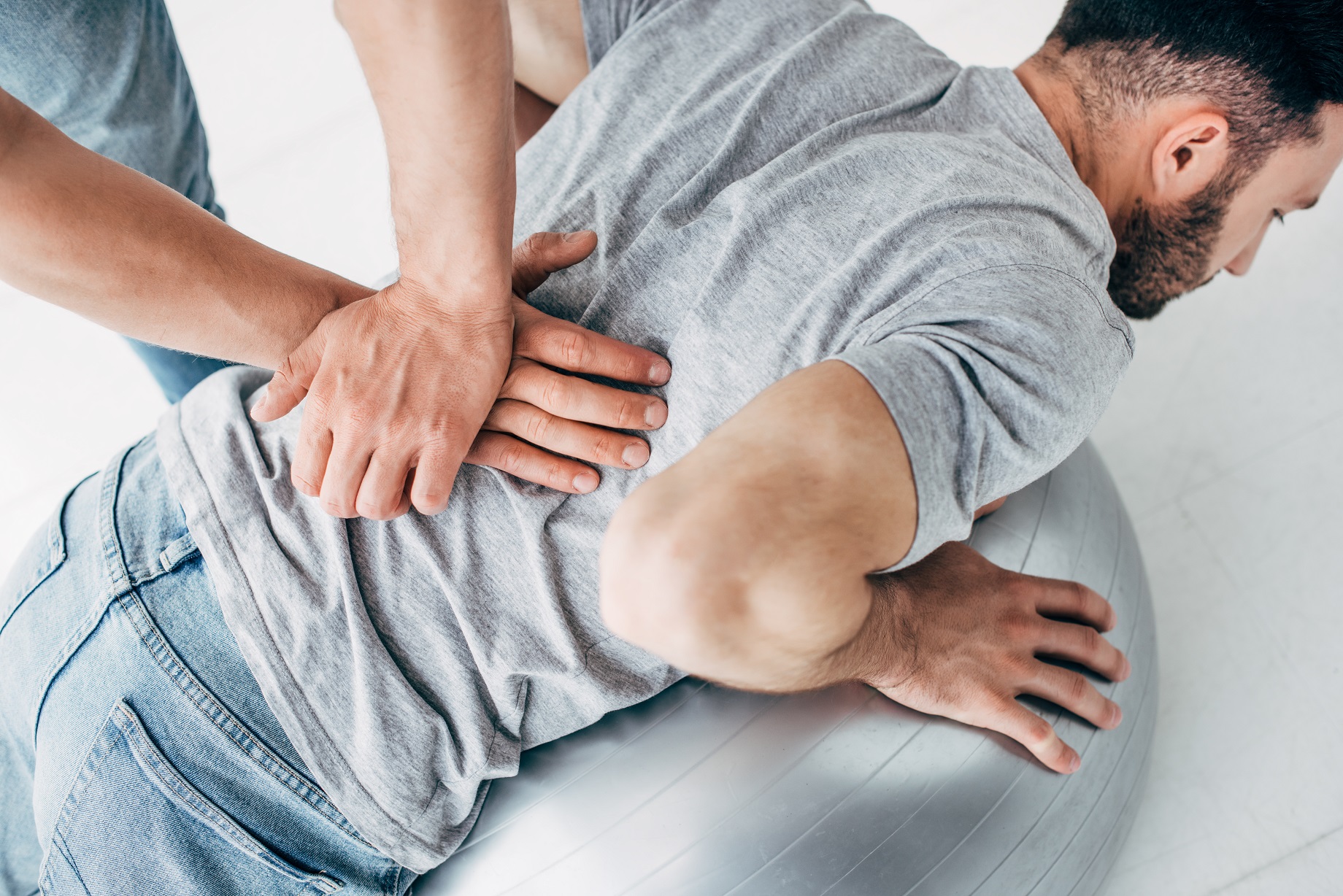 chiropractor massaging back of man lying