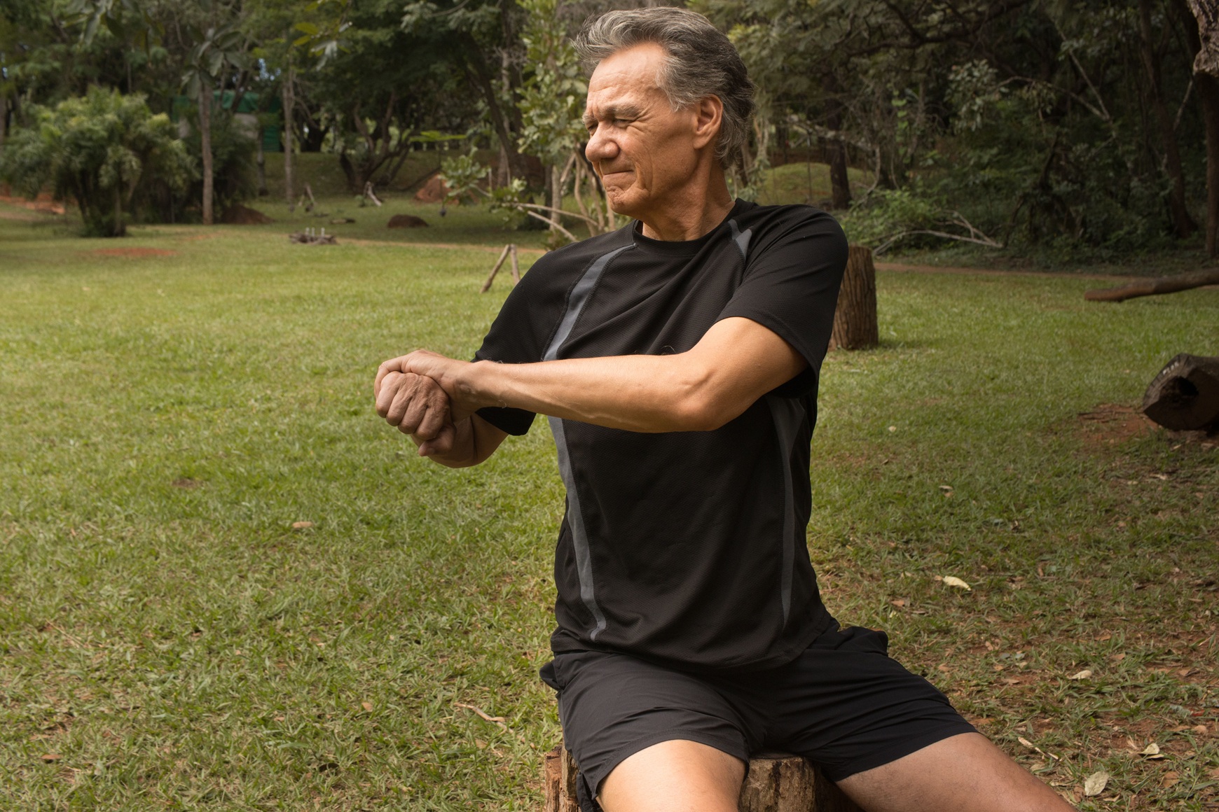 man stretching wrists outdoors on summer day 2026