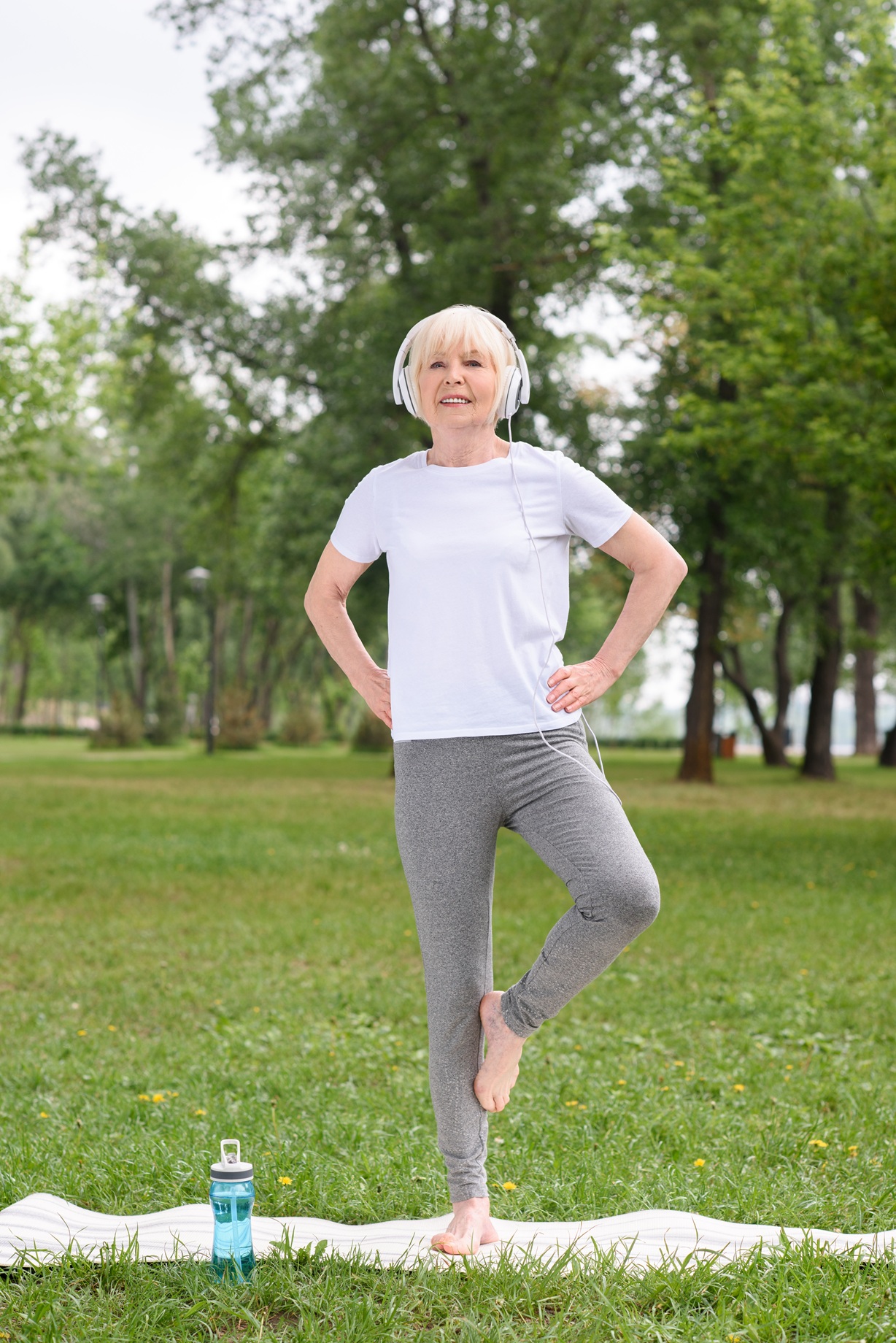 senior female yogi in headphones practicing on yog 2026