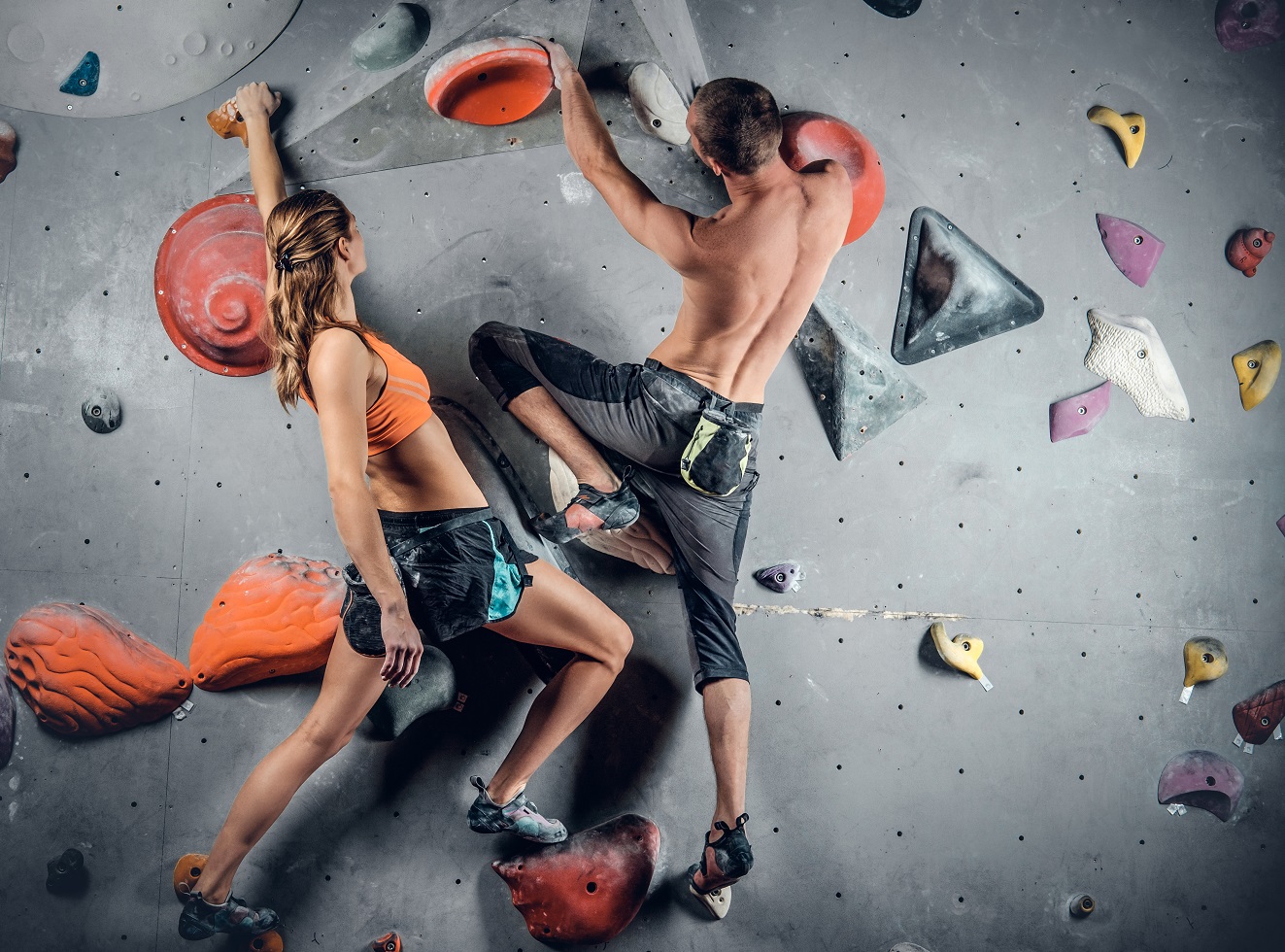 male and female climbing on a climbing wall