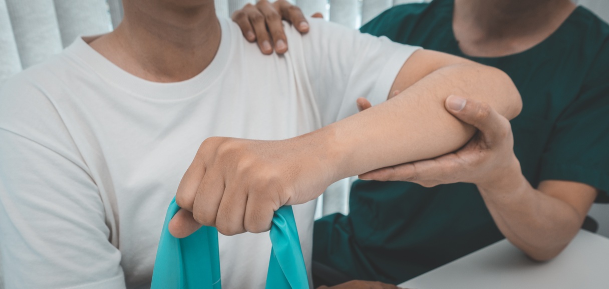 physical therapist working with patient using exer 2026