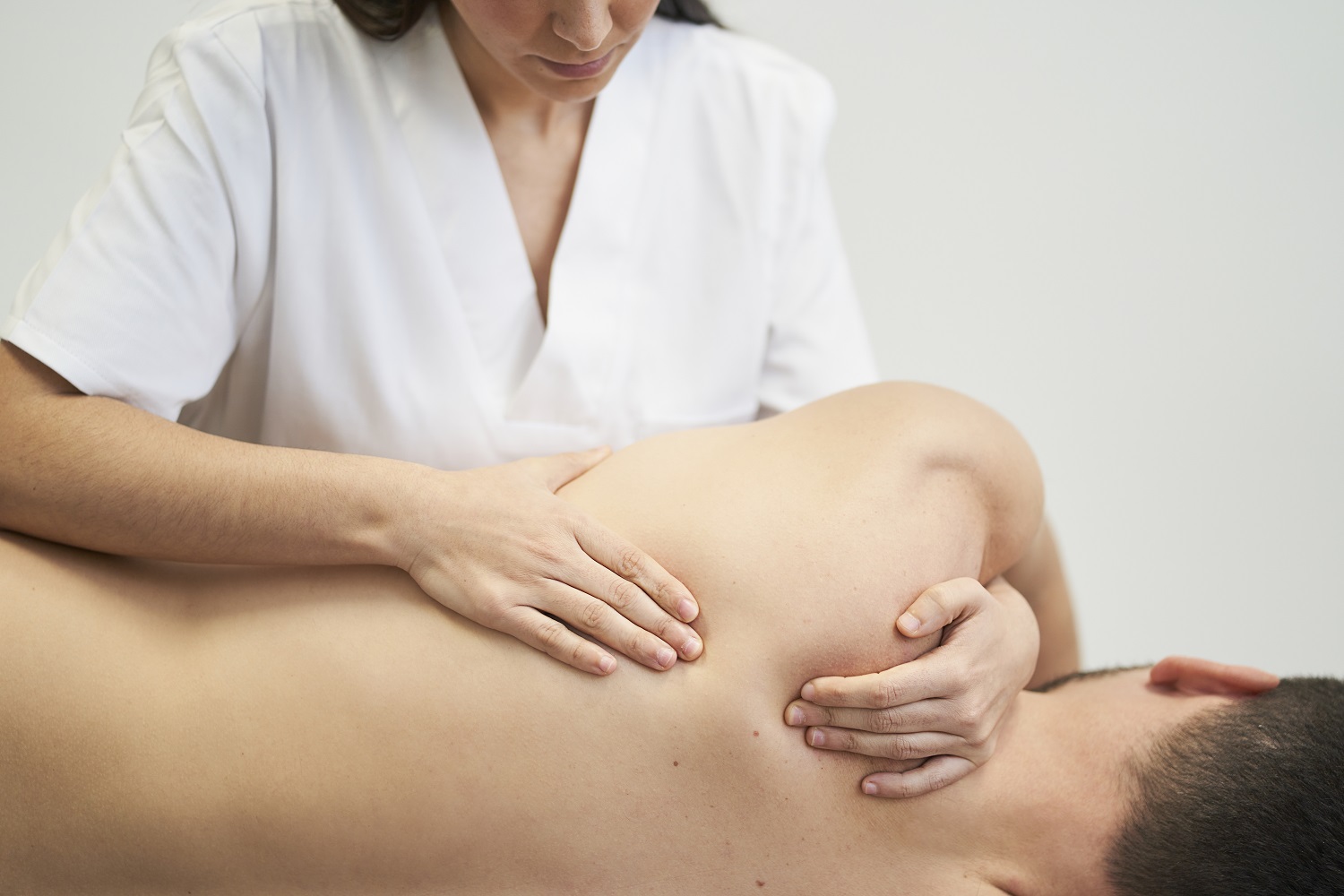 physiotherapist treating the patient s shoulder