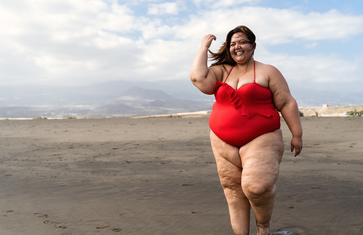 happy plus size woman having fun walking on the be