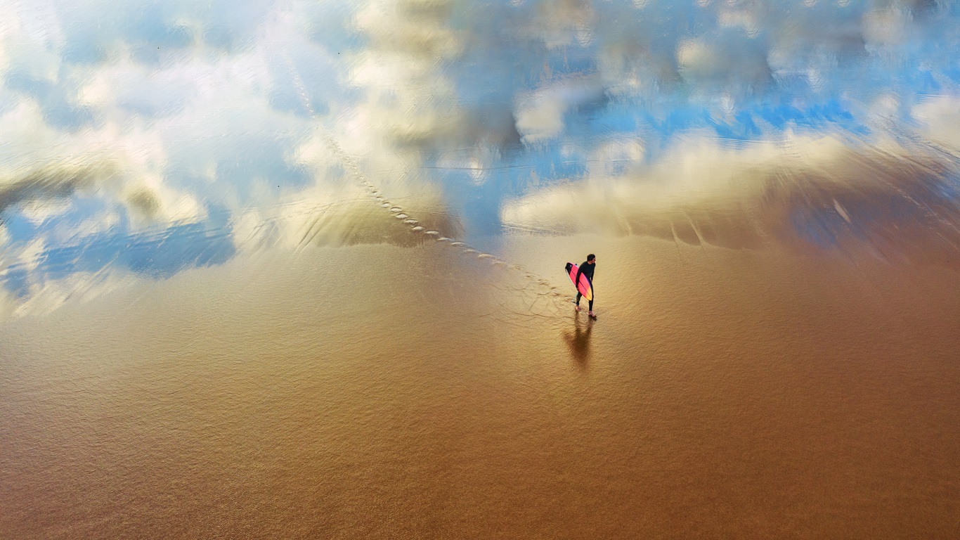 young surfer walking sandy beacha