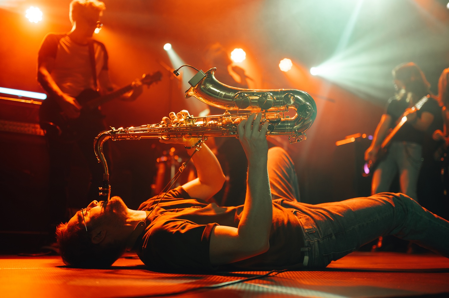 saxophone player performs on stage with band 2026