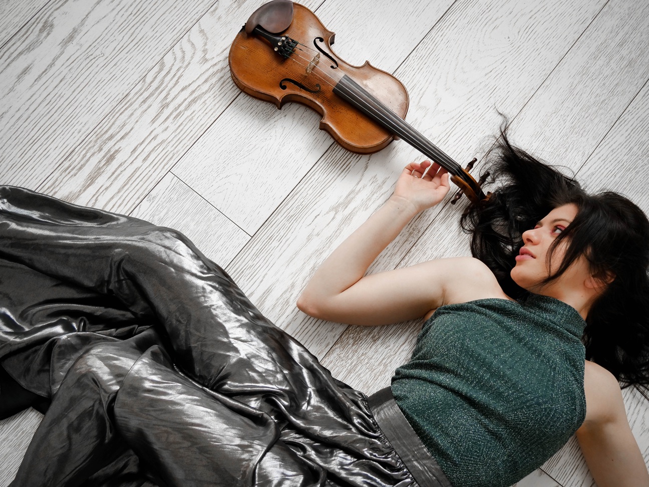 woman with violin lying on a wooden floor 2026