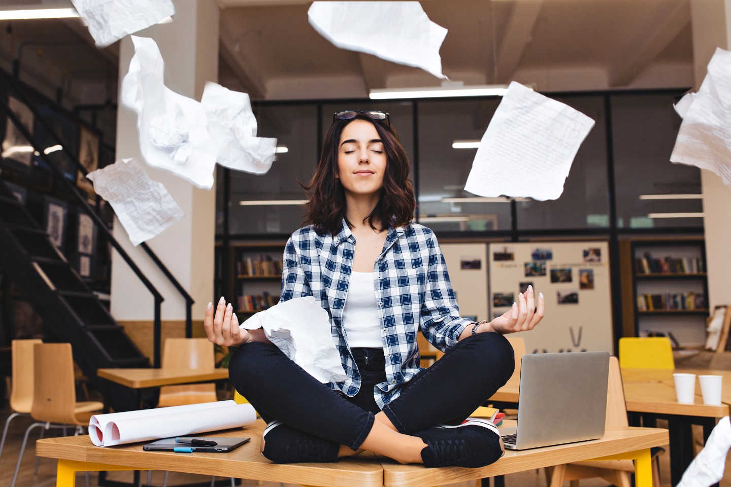young pretty joyful brunette woman meditating table surround work stuff flying papers cheerful mood taking break working studying relaxation