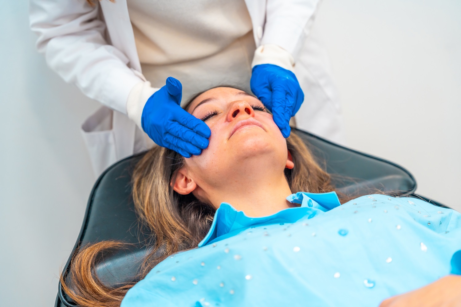 doctor applying numbing cream on woman s face